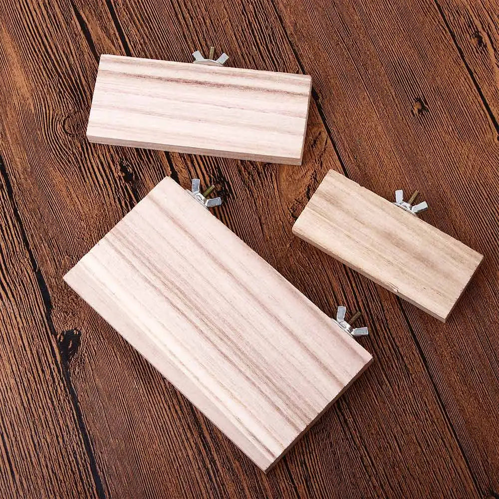 A light pink natural wood platform stand for birds or small pets, shown on a dark wooden surface.