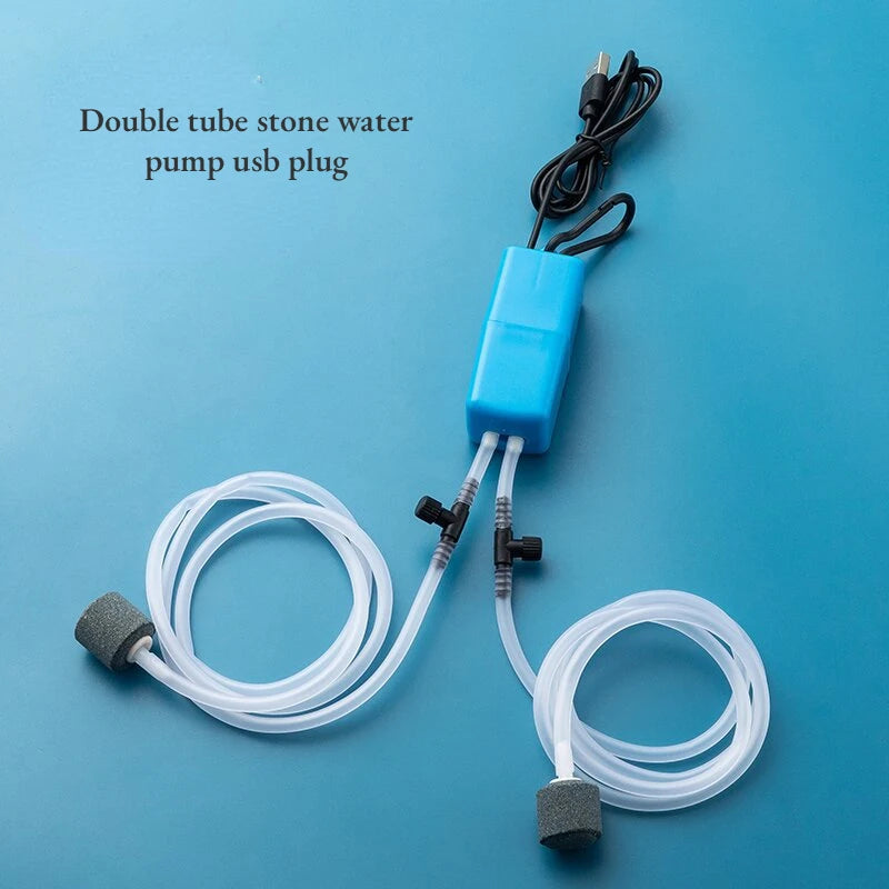 مضخة مياه حجرية مزدوجة زرقاء مع قابس USB وأنابيب شفافة على خلفية زرقاء فاتحة.