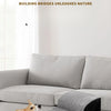A dog is resting on a gray memory foam pet ramp placed on a light-colored sofa.