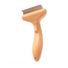 An orange pet grooming brush with a plastic handle and a comb attachment.
