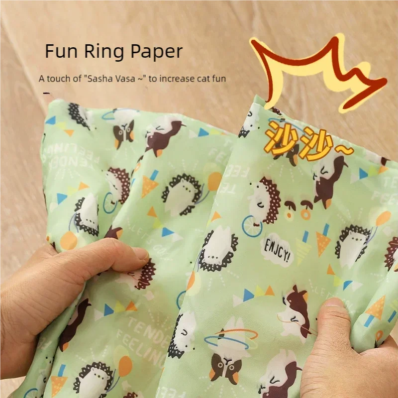 A hand holds a green fabric product called Fun Ring Paper with a cat pattern.