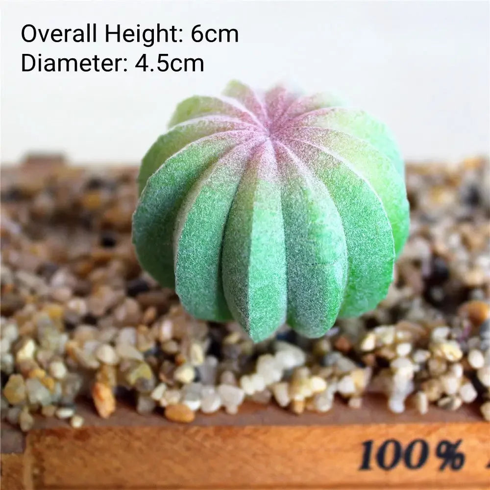 A small, round green flocked artificial succulent plant with a pink center is displayed on a wooden surface.