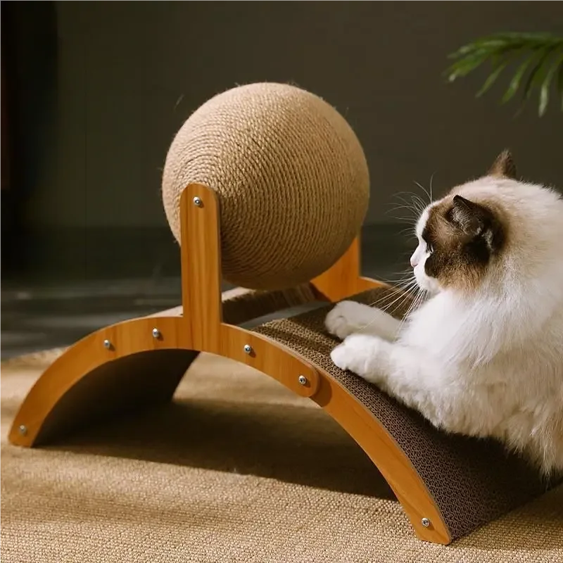 Un chat blanc se repose sur un poteau à griffer en bois avec une grande boule de sisal.