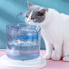 A white cat is drinking water from a motion-activated pet water fountain with a filter.