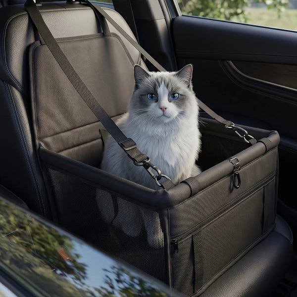 A fluffy gray cat is sitting inside a black portable dog car seat travel carrier with adjustable safety straps.