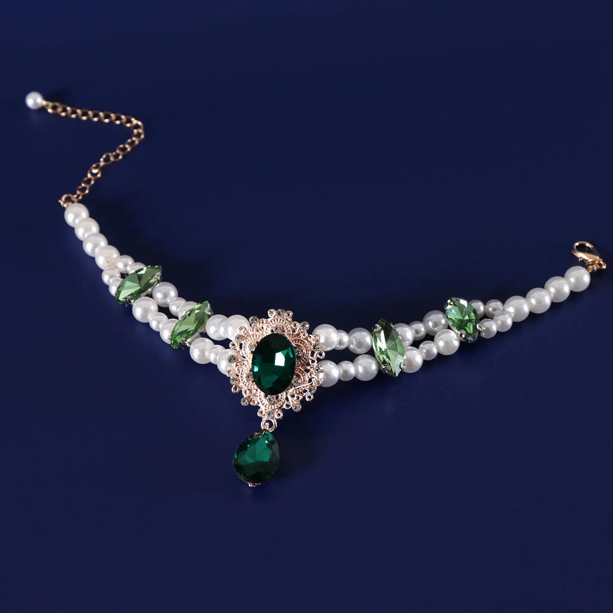 A delicate pearl collar featuring green gemstones and gold accents for pets.