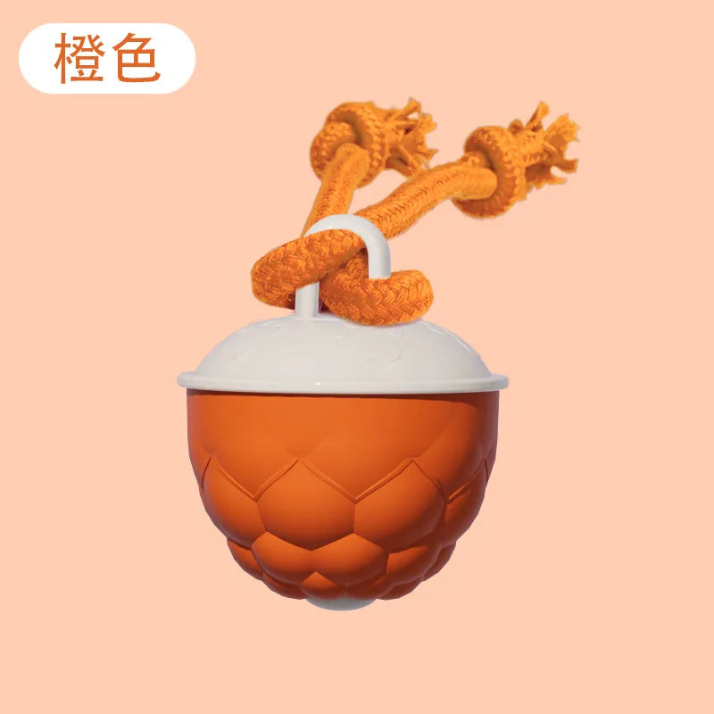An orange interactive rolling dog ball with a white top and braided orange string.