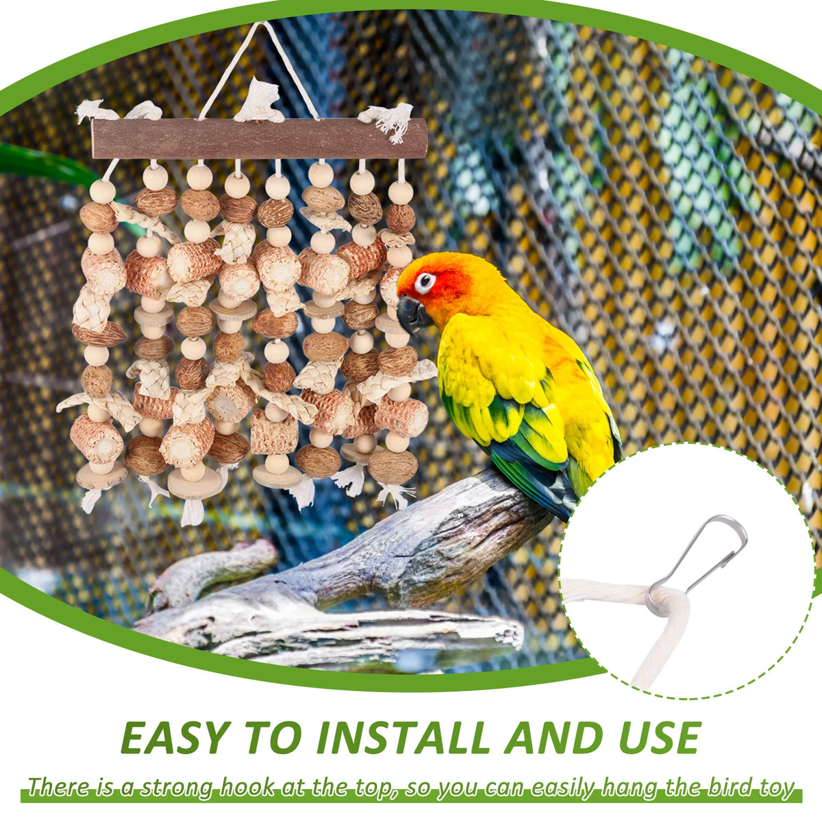 A yellow parrot is perched on a wooden branch in a wire cage, with a hanging toy visible nearby.