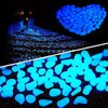 A heart shape formed by glowing blue stones on a dark surface.