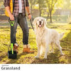 A person is using a foldable pet poop scooper to clean up dog waste on the grass.