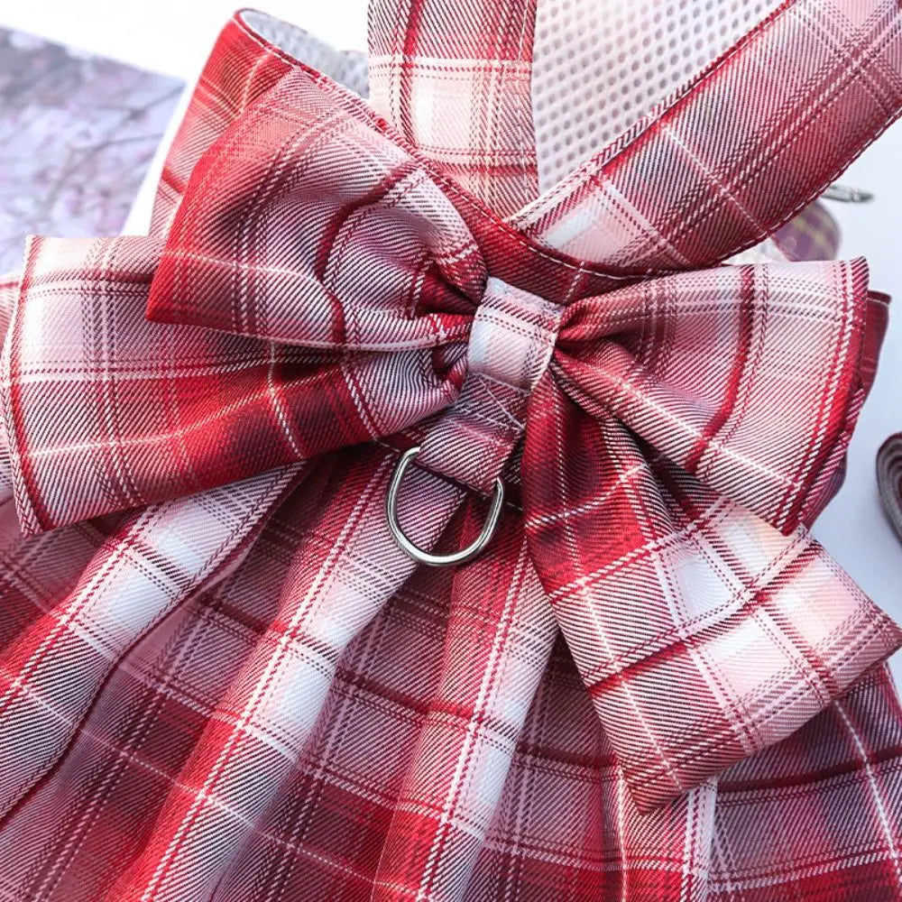 A plaid red and white fabric bow detail on a reusable dog harness dress.