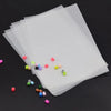 A set of precision hama beads tweezers with various colored plastic beads displayed on a sheet of clear plastic.