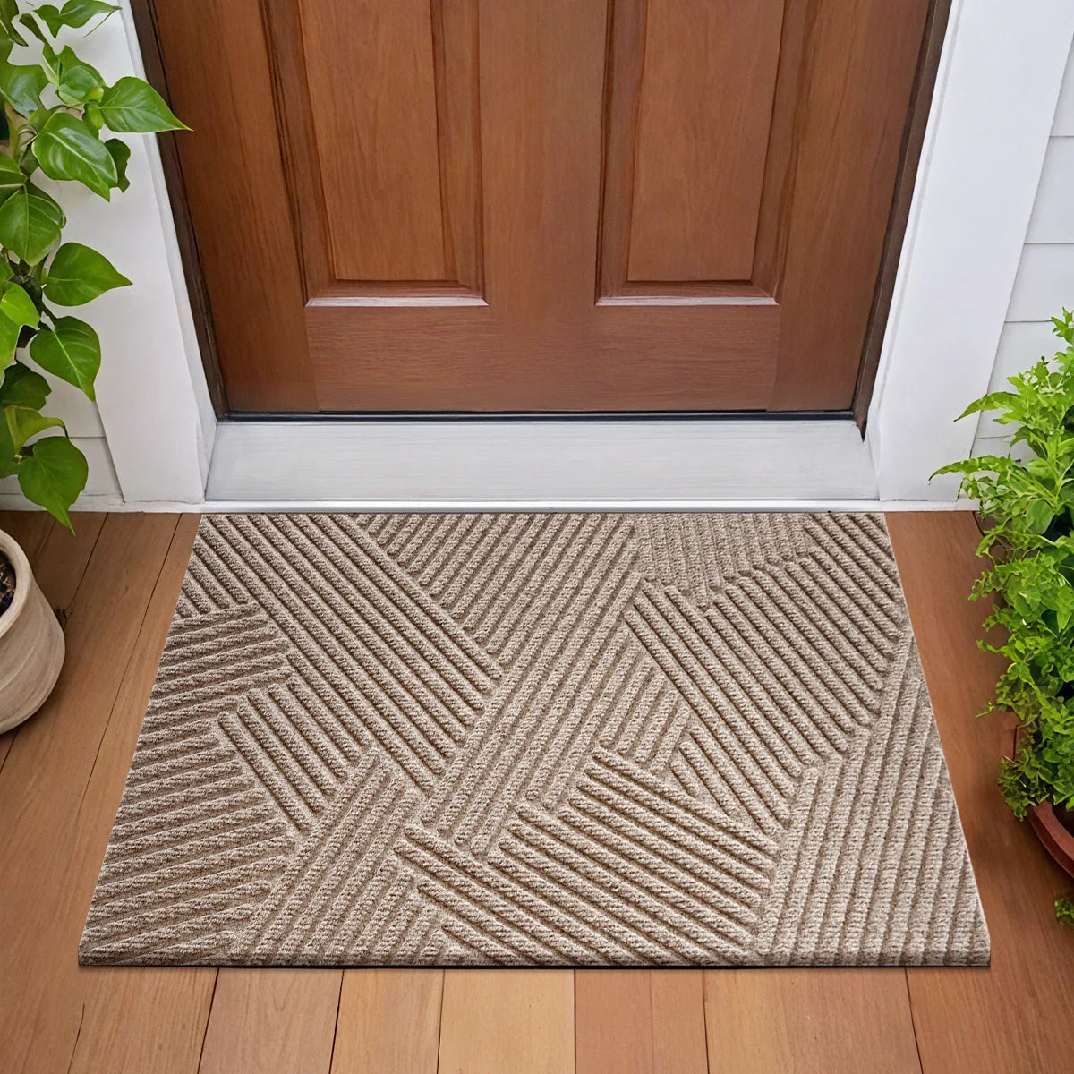 A rectangular beige geometric doormat with a textured, woven pattern placed on a wooden floor in front of a brown door.