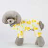 A fluffy gray dog wearing a yellow patterned cotton pajama top.