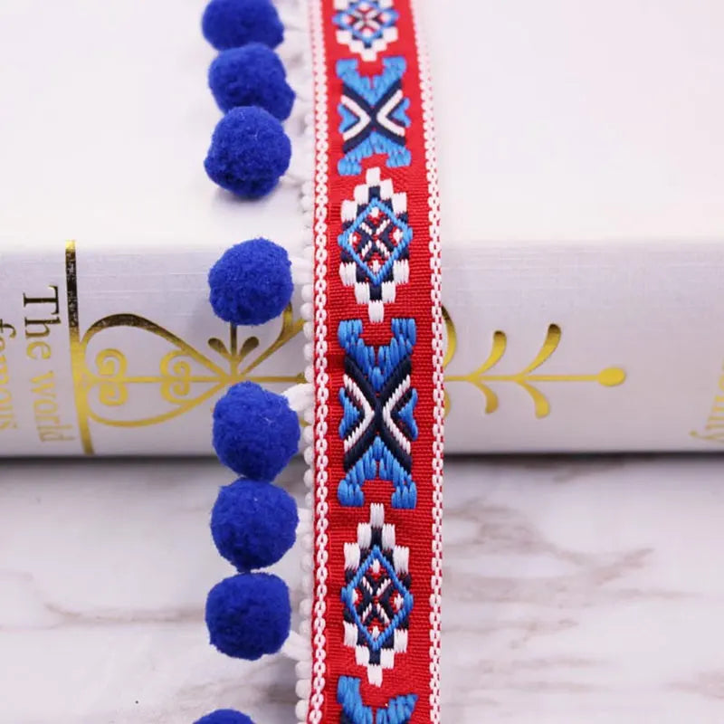Red and white lace trim with blue pom poms used for sewing and DIY crafts
