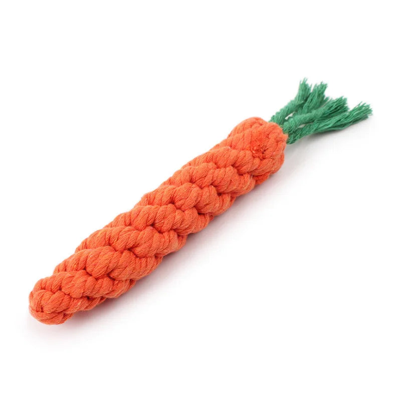 An orange carrot plush toy made of yarn with green leafy top