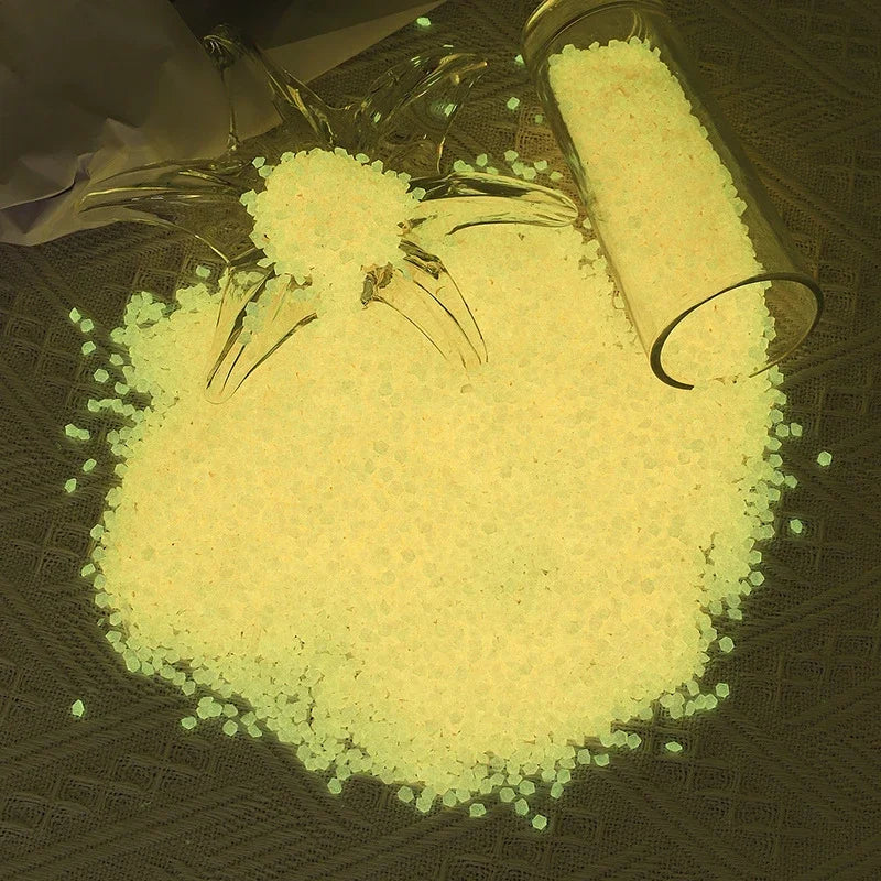 A pile of bright yellow glow-in-the-dark decorative pebbles is shown next to a glass jar.