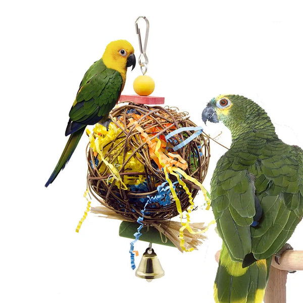 A yellow and green parrot is perched next to a natural rattan hanging chew toy for small parrots.