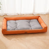 An orange corduroy pet sofa bed for dogs and cats resting on a light wooden floor.