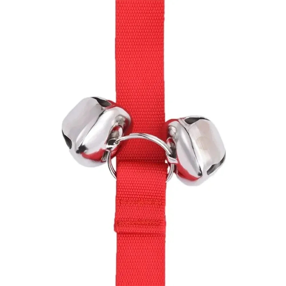 A red adjustable dog doorbell strap with silver metal bells.