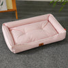 A pink, rectangular pet sofa bed for dogs and cats resting on a gray carpet.