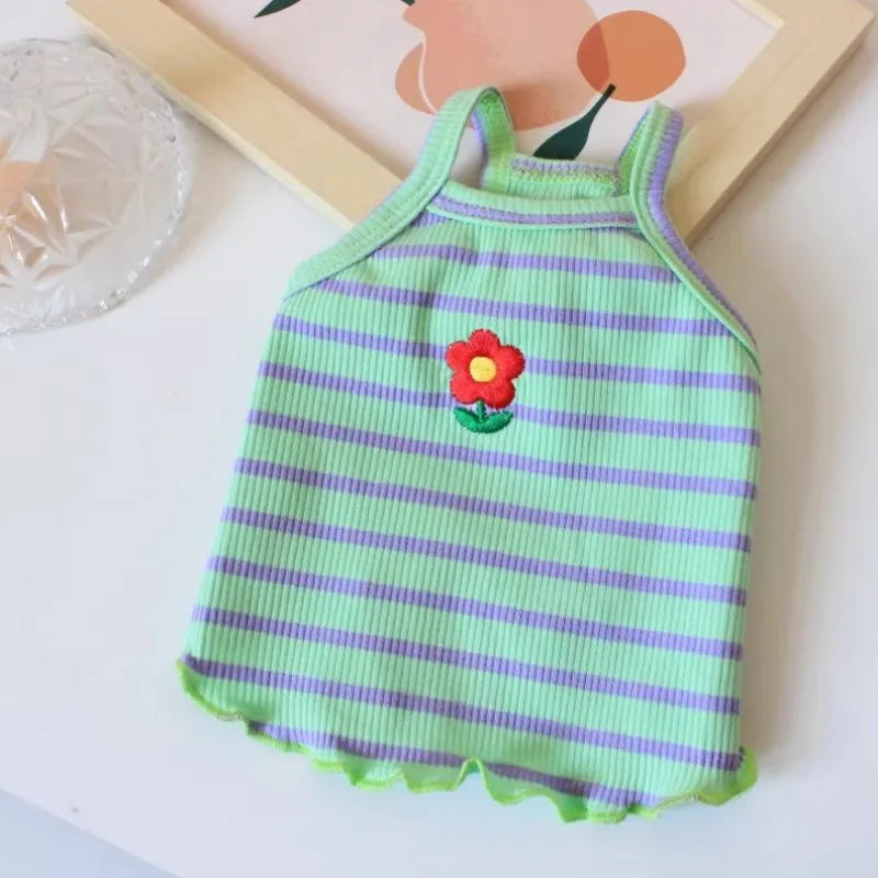 Ein grün-lila gestreiftes Kühlvest für Hunde mit einer roten Blumenapplikation.