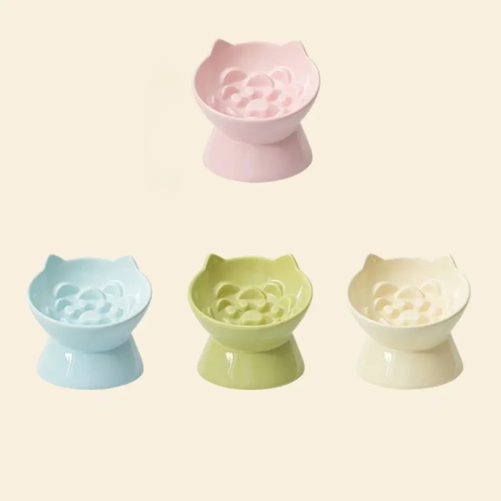 Three ceramic pet food bowls in pink, light green, and off-white with a raised slanted design.