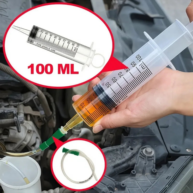 Eine Hand hält eine Plastikspritze mit einer Nadel und entnimmt Öl aus einem Motorteil.