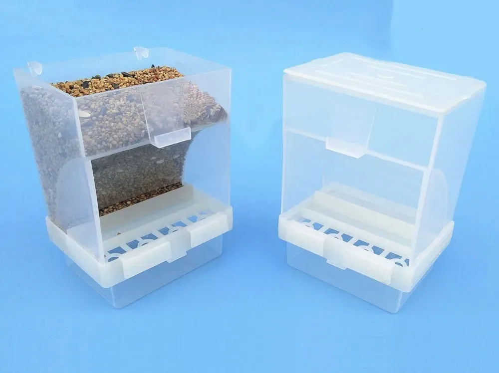 Klarer Plastikautomat für Vögel mit Vogelfutter, von der Seite gezeigt.