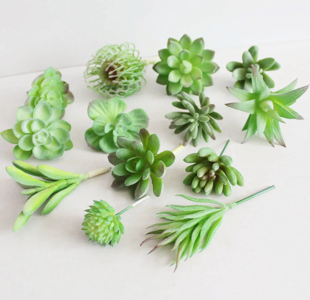 A collection of green fake succulent plants in various stages and shapes for desktop décor.
