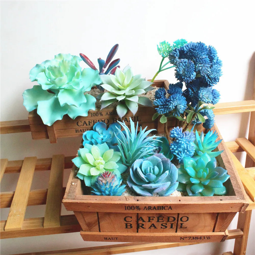 A collection of blue and green artificial succulent plants displayed in a wooden box.