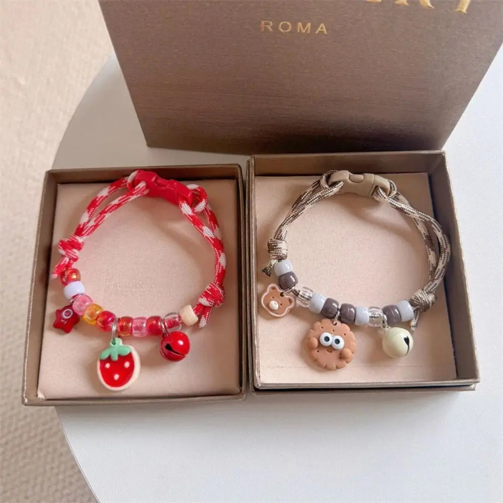 A set of colorful braided pet collars with bells for cats and small dogs displayed in a box.