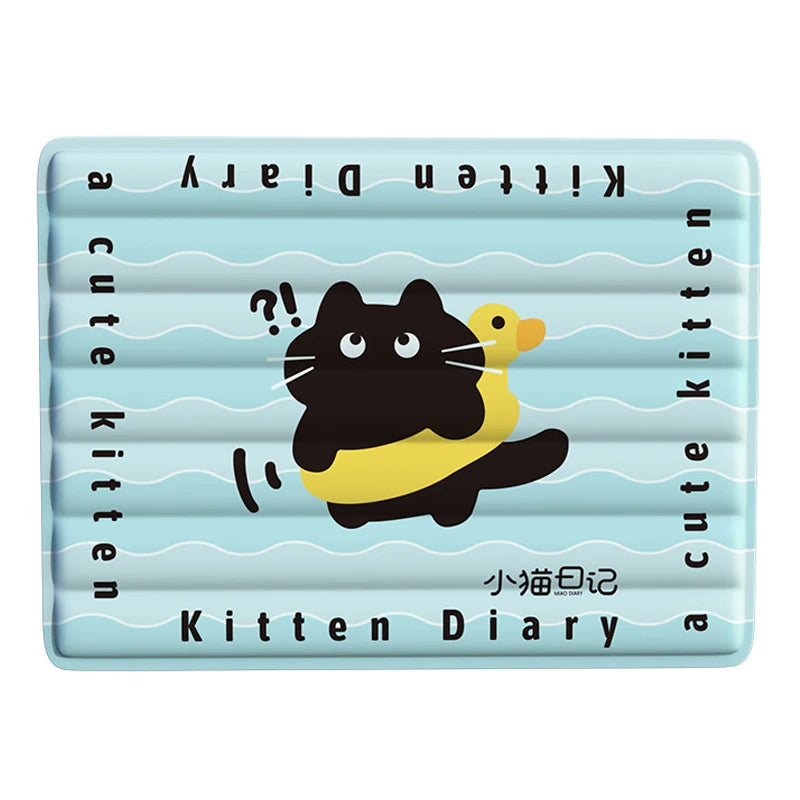 A light blue silicone diary mat with a black and yellow kitten illustration and text.