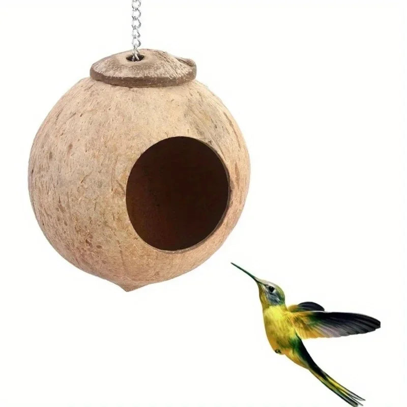 A natural coconut shell bird nest hanging from a chain, showing an entrance hole.