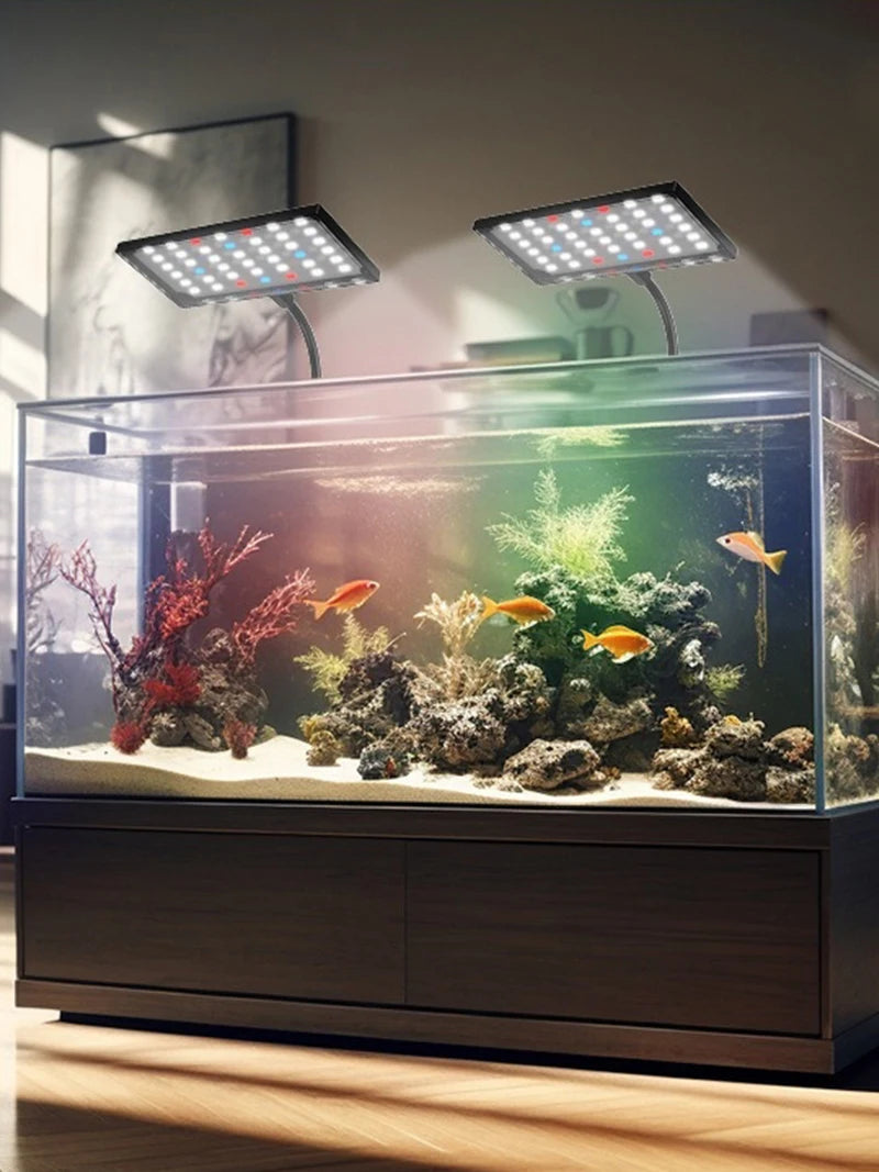 A glass aquarium display featuring tropical fish and aquatic plants illuminated by a full spectrum LED grow light.