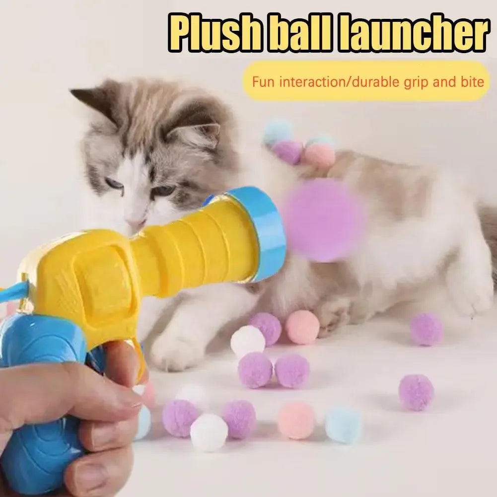 A cat is interacting with a yellow plush ball launcher toy and colorful soft balls.