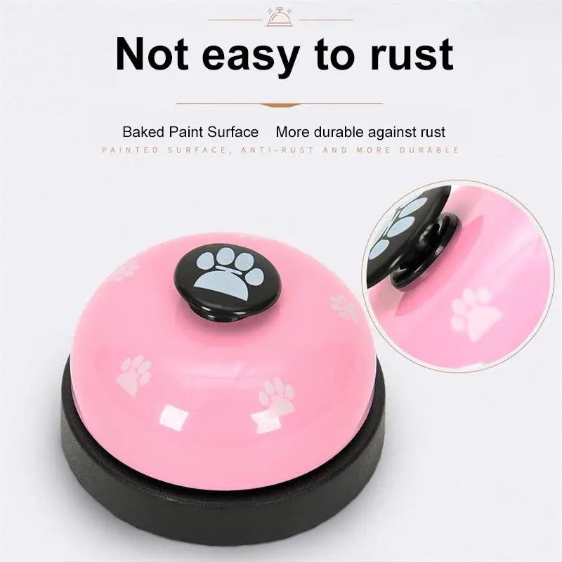 A pink and black footprint pet training bell with a silicone surface shown on a black base.
