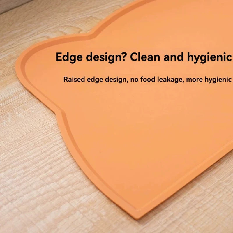 Orange silicone cat face pet feeding mat with a raised edge design for hygiene