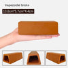 A hand holds a terracotta trapezoidal brick, showing its shape and texture.