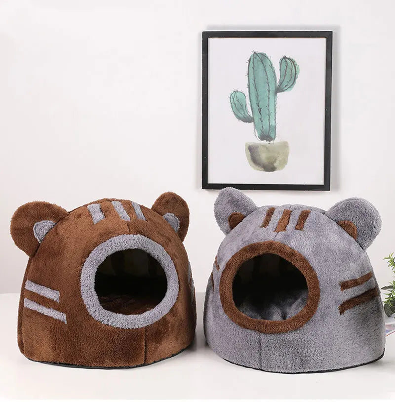 Plüschiger brauner Bärenkopf Katzenbett mit großen Ohren und einer Öffnung, neben einem gerahmten Kaktusgemälde.
