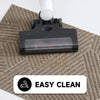 A black doormat with a clear plastic top is placed on a beige woven mat.