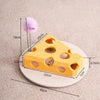 A yellow felt maze puzzle toy shaped like a block with holes, next to a purple pom-pom and measuring tape.