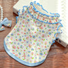 A floral vest for dogs and cats featuring light pink, blue, and white patterns with ruffled trim.