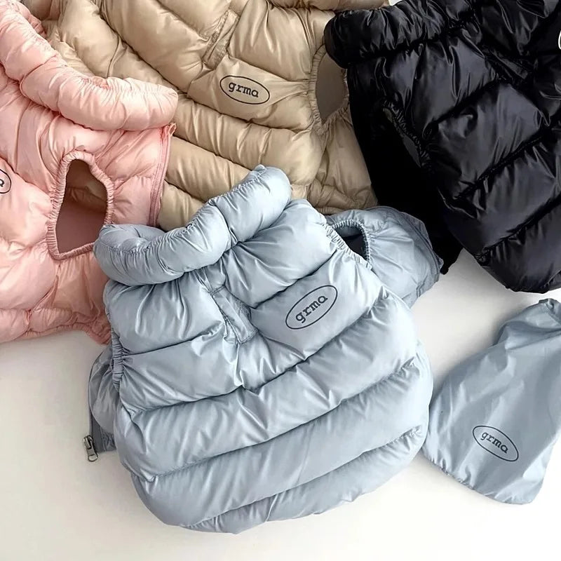 Ein Stapel weicher Winterkleid für Hunde und Katzen in rosa, beige und hellblau.
