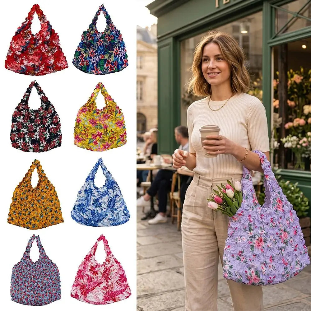 A woman holds a purple floral shopping tote bag in a light outdoor setting.