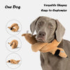 A gray dog is holding a tan plush toy shaped like a coiled snake for a versatile dog toy.