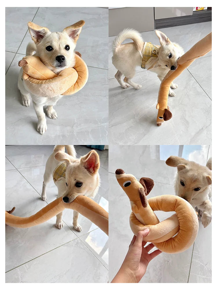 A fluffy dog is playing with an orange squeaky plush toy shaped like a dachshund.