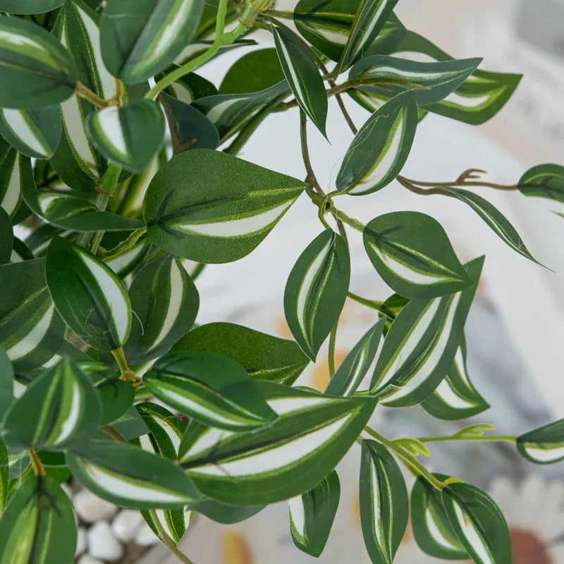 Artificial bonsai tree with green leaves featuring white stripes, used for home and office decor.