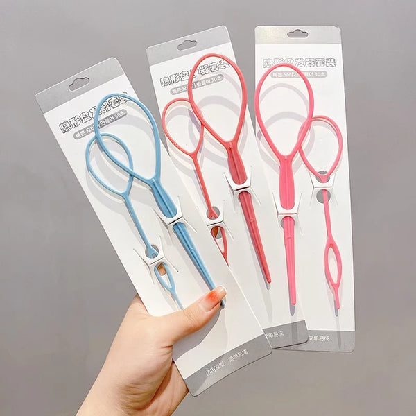 Una mano sostiene un paquete de clips para peinar el cabello en rosa y azul.