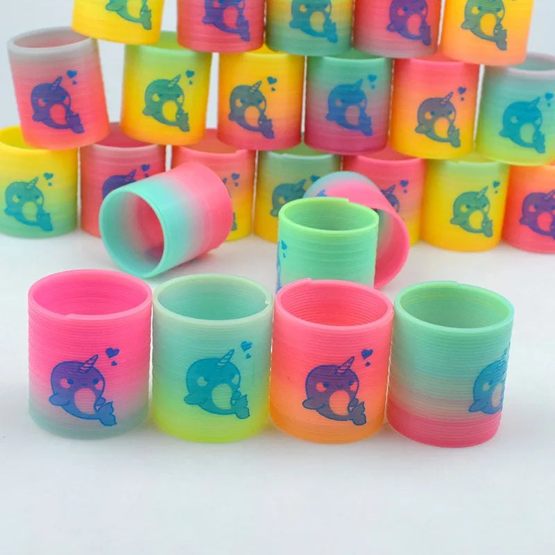A set of twelve colorful spring coil toys in shades of pink, yellow, and green with unicorn designs.